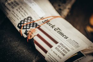 A rolled and banded copy of The New York Times with President Joe Biden on the front page