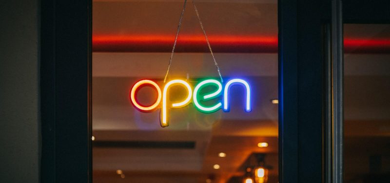 Illumiated multi-color neon open sign in store window 